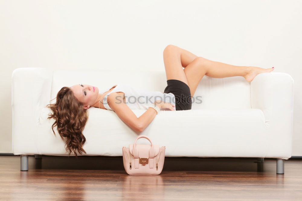 Similar – tall young leggy woman sits barefoot on light couch with bare legs