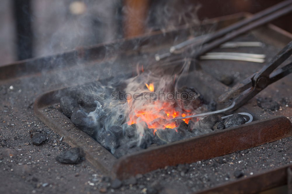 Similar – Blacksmith forges iron on anvil