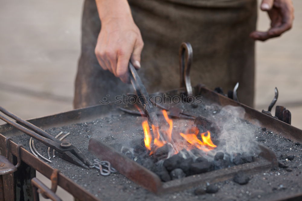 Similar – Blacksmith forges iron on anvil