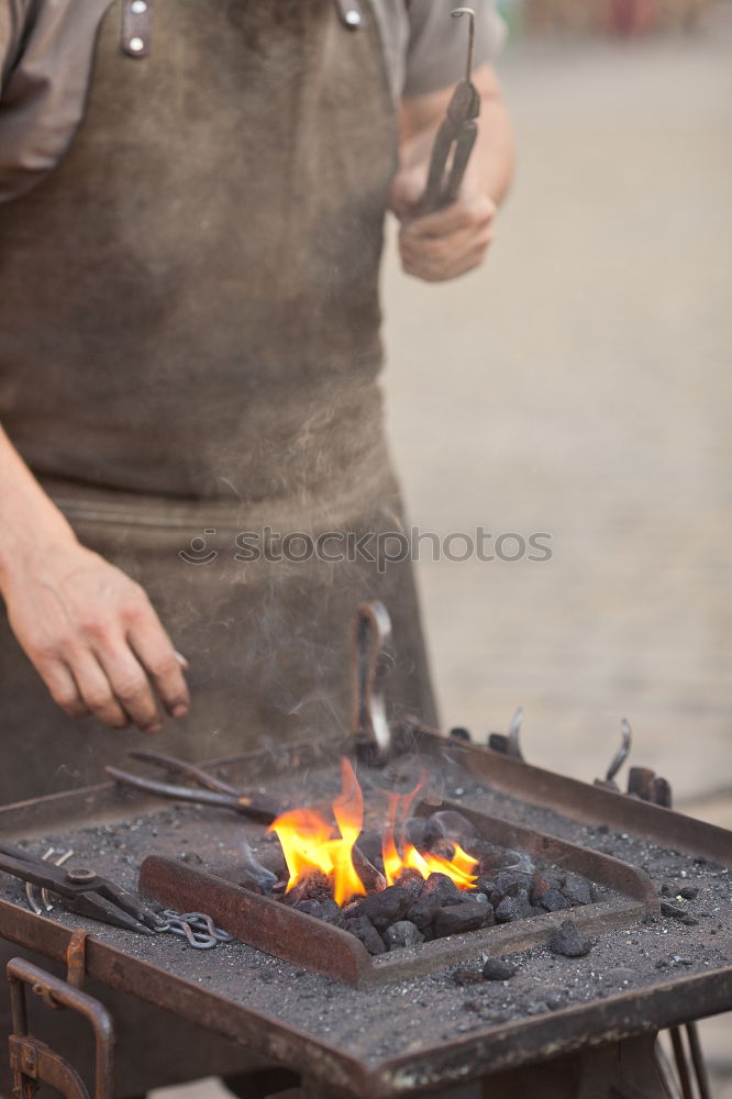 Similar – Blacksmith forges iron on anvil