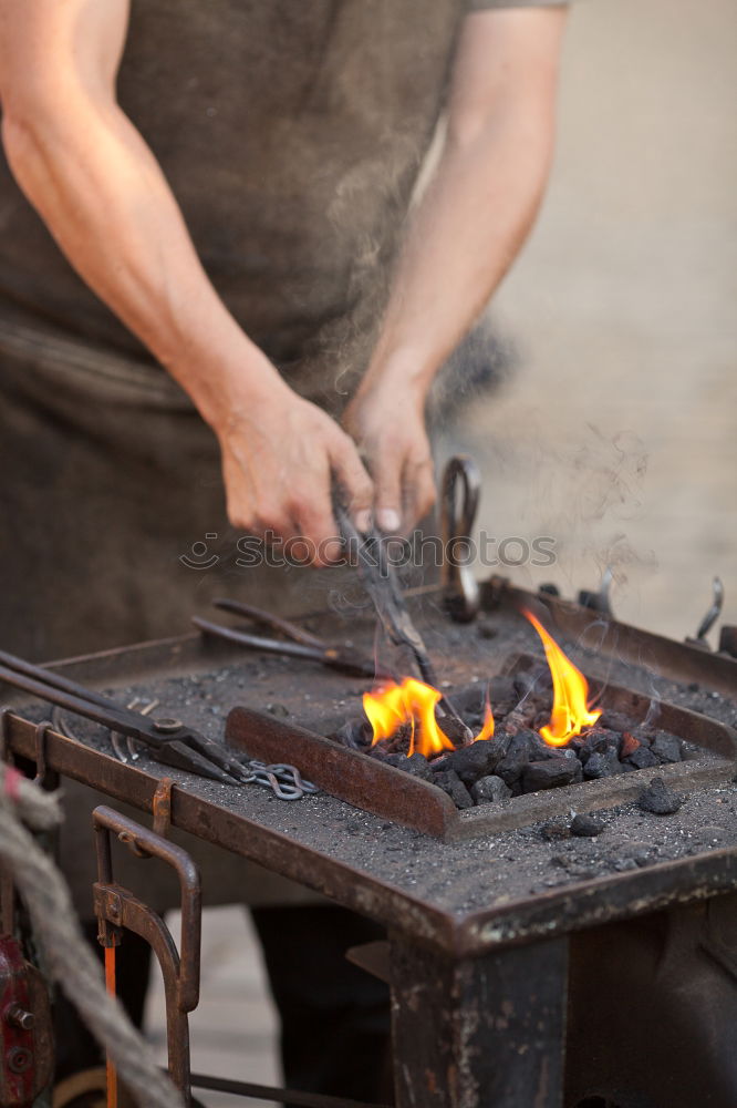 Similar – Blacksmith forges iron on anvil