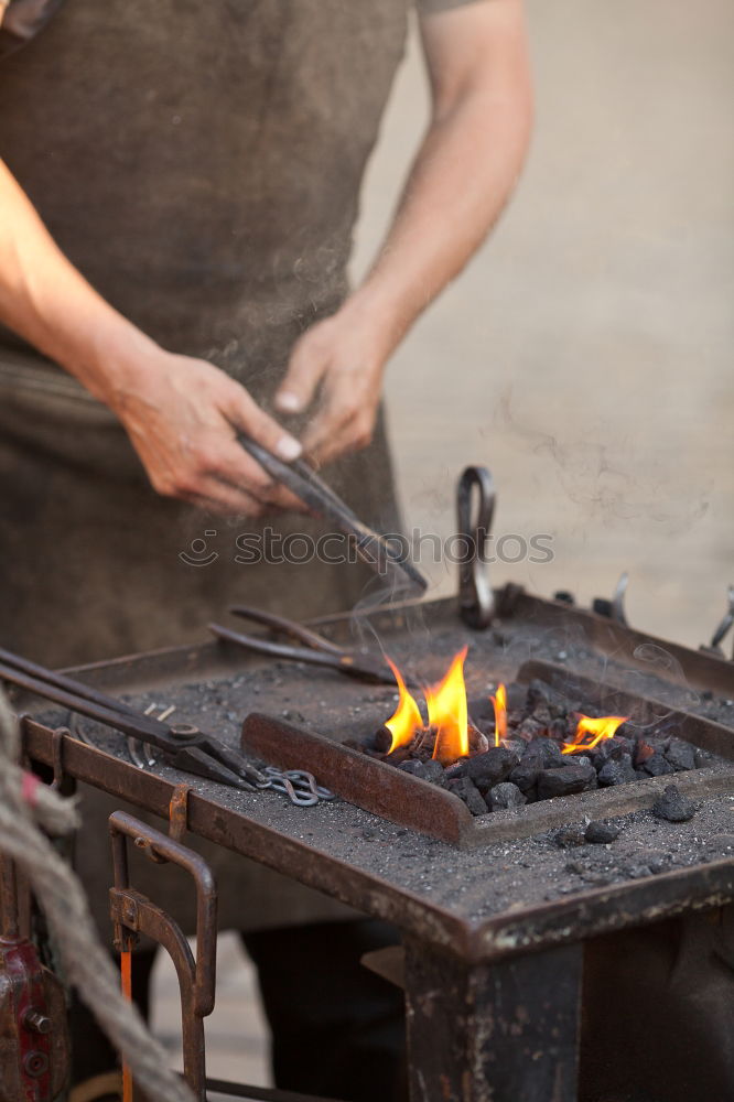 Similar – Blacksmith forges iron on anvil