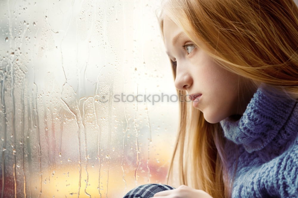 Similar – Woman looking into window pane with reflection