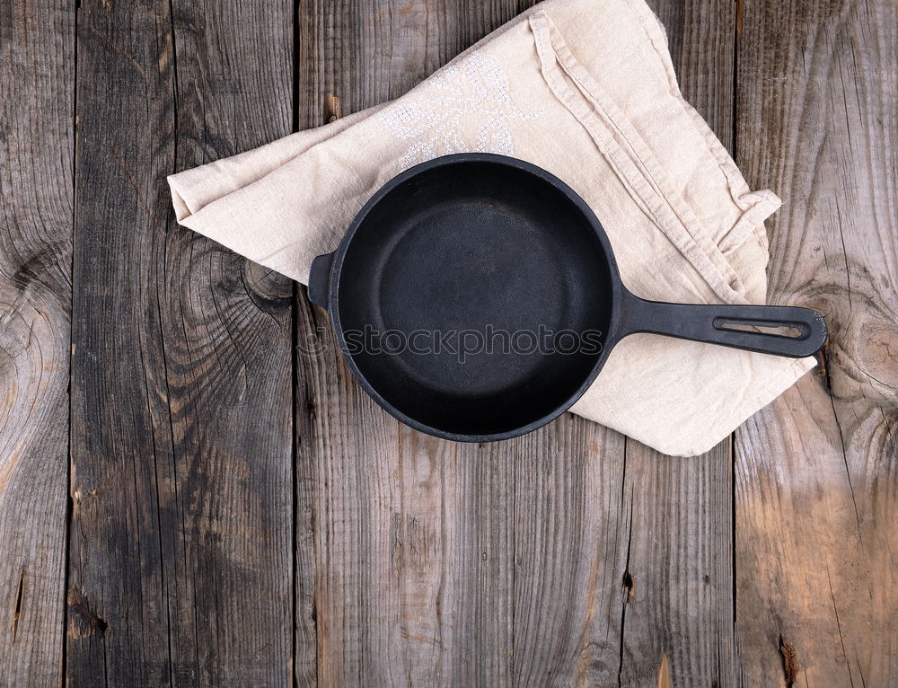 Similar – Black frying pan with a kitchen spatula, brown surface