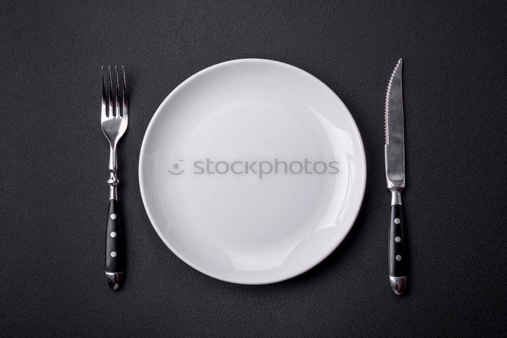 Half empty white plates, vintage knife and fork