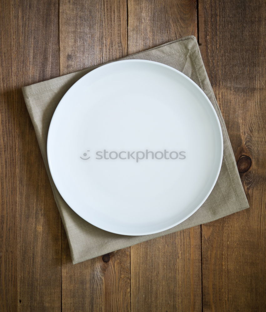 Similar – plate with a fork and knife on a brown wooden surface