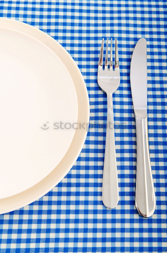 Similar – Crossed knife and fork on an empty white plate