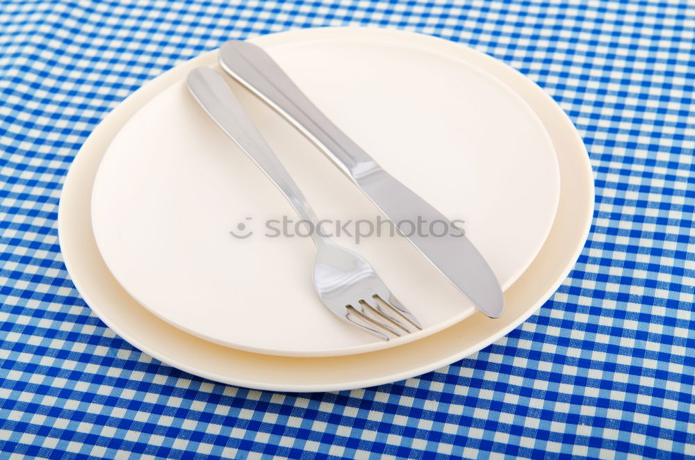 Similar – Crossed knife and fork on an empty white plate