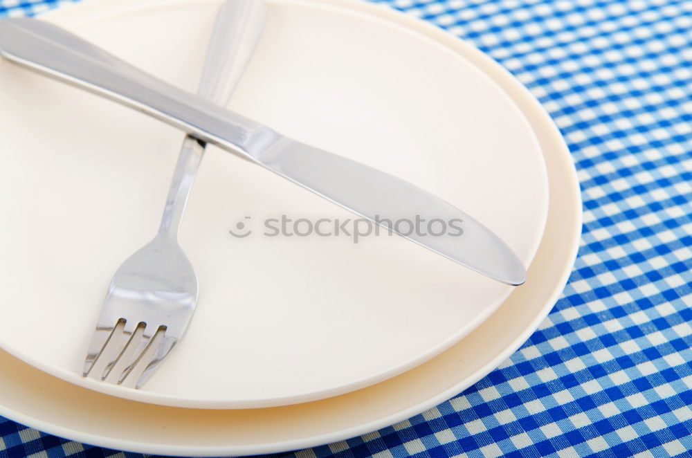 Similar – Crossed knife and fork on an empty white plate