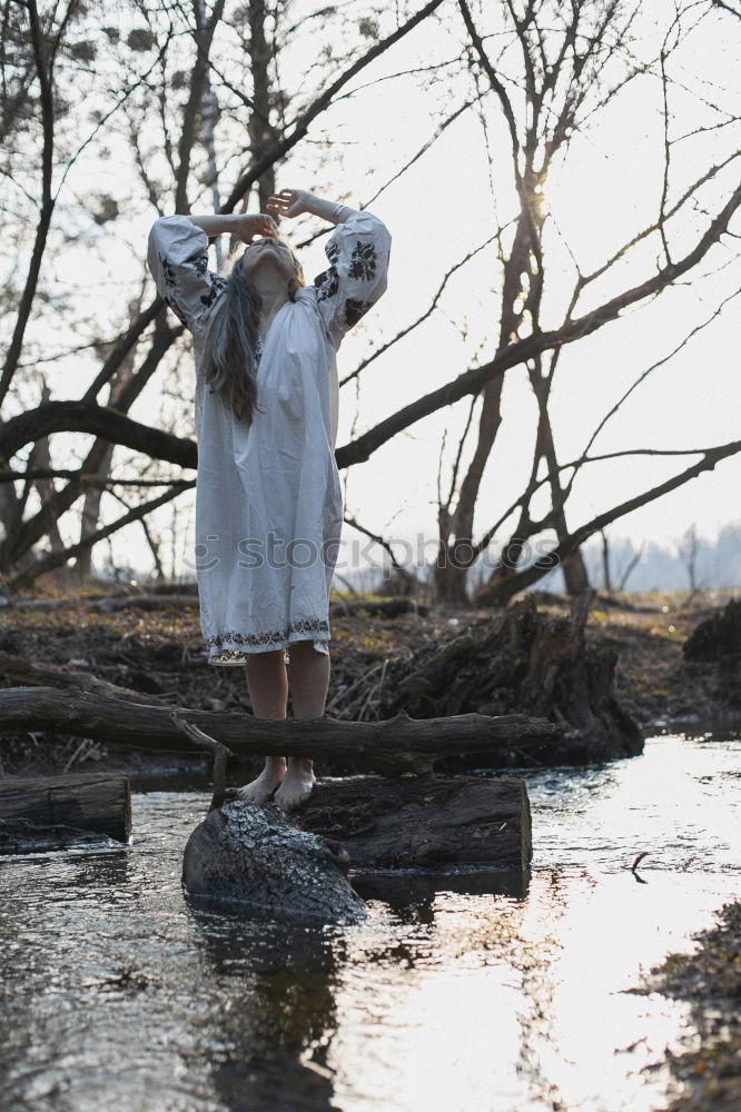 Similar – Woman posing on ground near dry trees