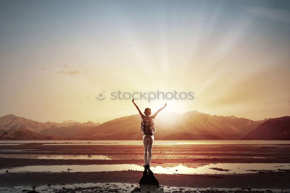 Similar – Young woman building bridge on beach backlit in front of massive cliff