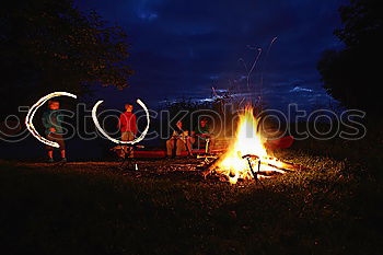 Similar – Image, Stock Photo Man lights a fire in the fireplace in nature at night