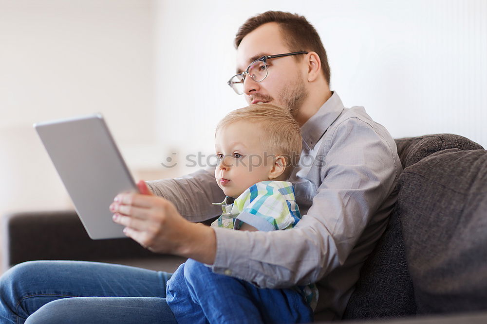 Similar – Mother reading a book to her baby son