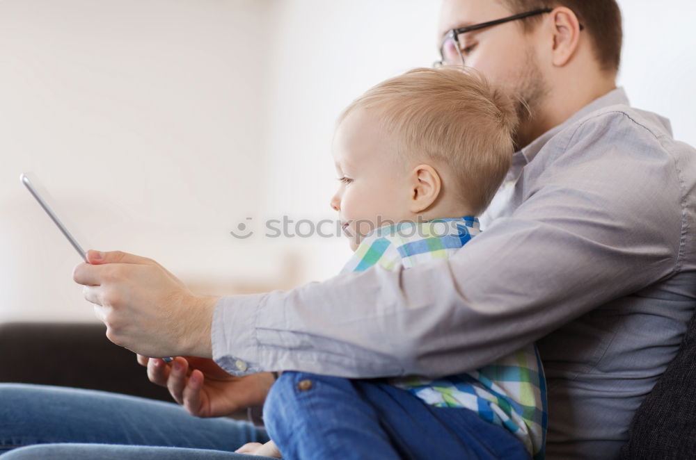 Similar – Mother reading a book to her baby son