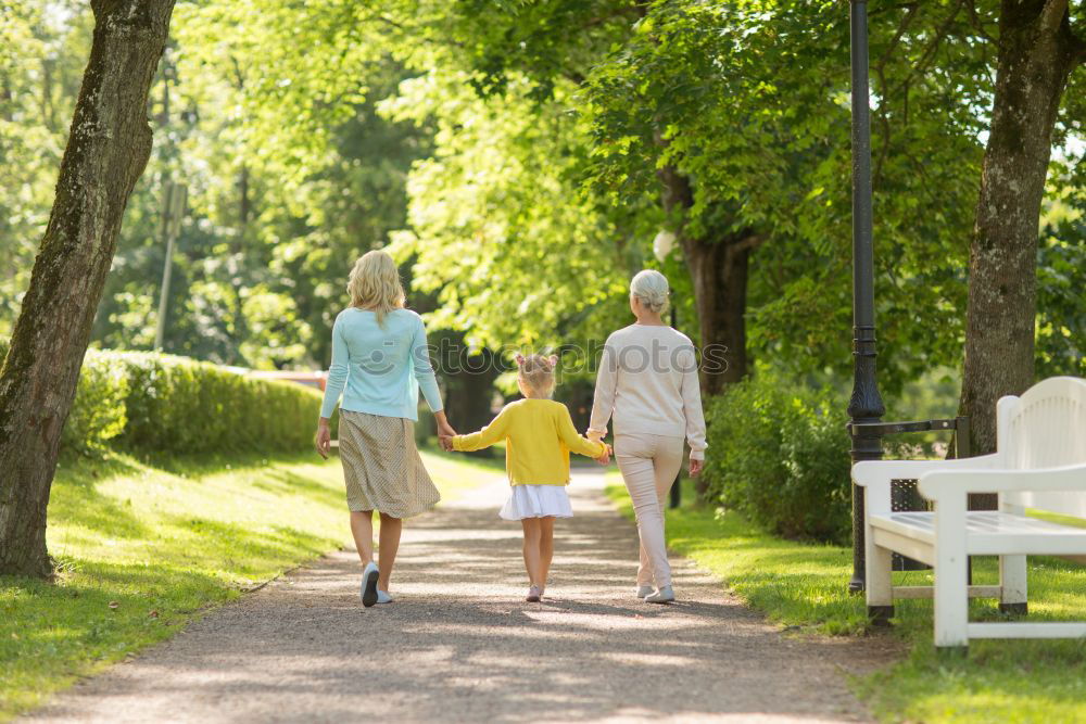 Similar – Grandparents and grandchild jumping on nature path