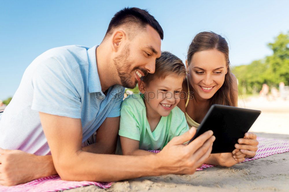 Young happy couple using smart phone sitting in the park