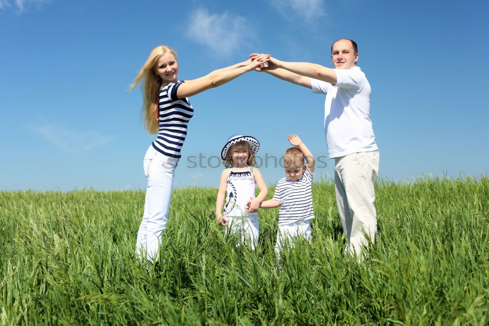 Similar – happy family of four hand in hand on the field