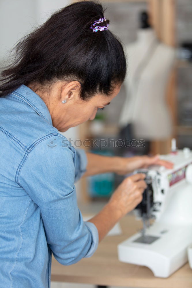 Similar – Women sew on sewing machine