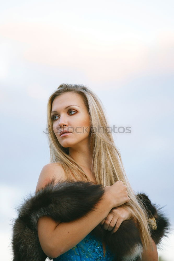 young woman 30 years in snow with red coat and leopard dress blond hair curly happy hopeful street