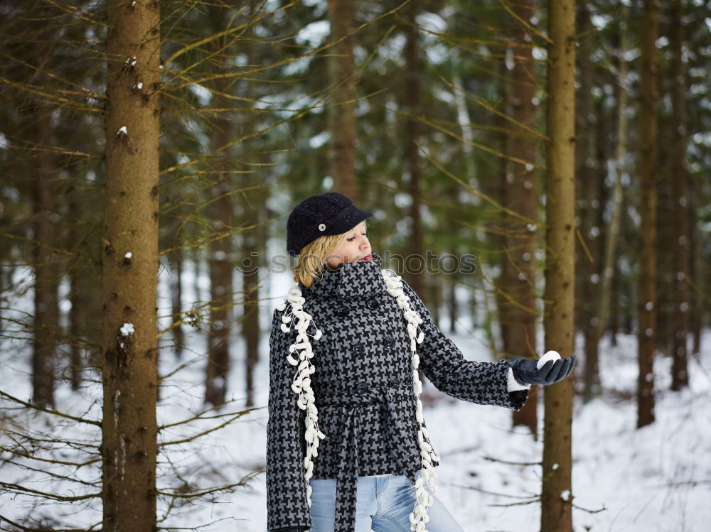 Similar – woman leaning against tree in winter landscape