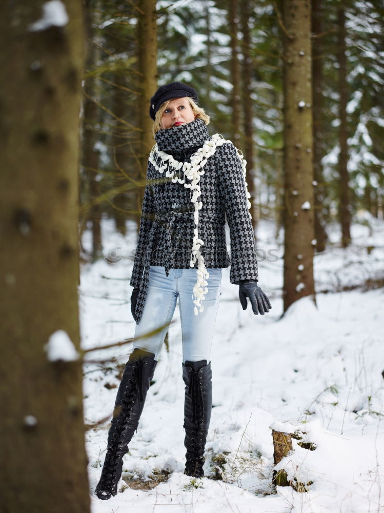 Similar – woman leaning against tree in winter landscape