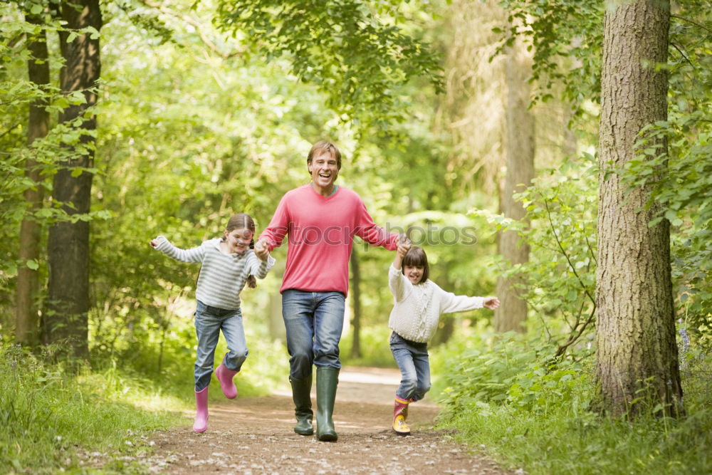 Similar – Grandparents and grandchild jumping on nature path