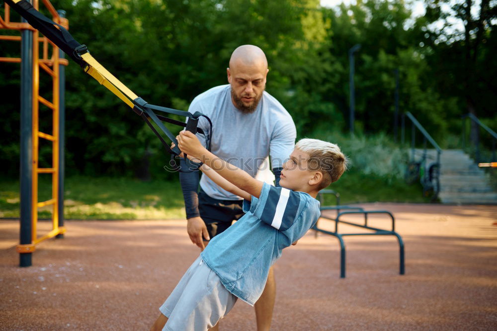 Similar – Image, Stock Photo Cheerful young man teaching his son to play mini golf