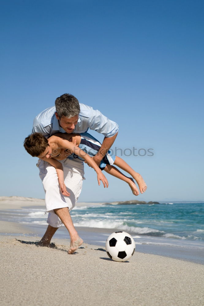 Similar – Image, Stock Photo Father and son playing football on the beach at the day time. Concept of friendly family.