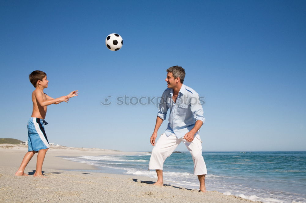 Image, Stock Photo Father and son playing football on the beach at the day time. Concept of friendly family.