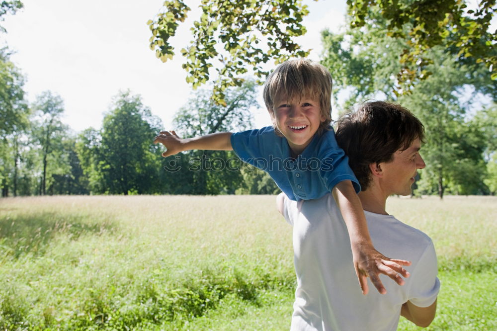 Similar – Back view of senior man holding adorable baby girl in his arms over a nature background