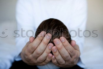 Similar – one sad woman sitting near a wall and holding her head in her hands