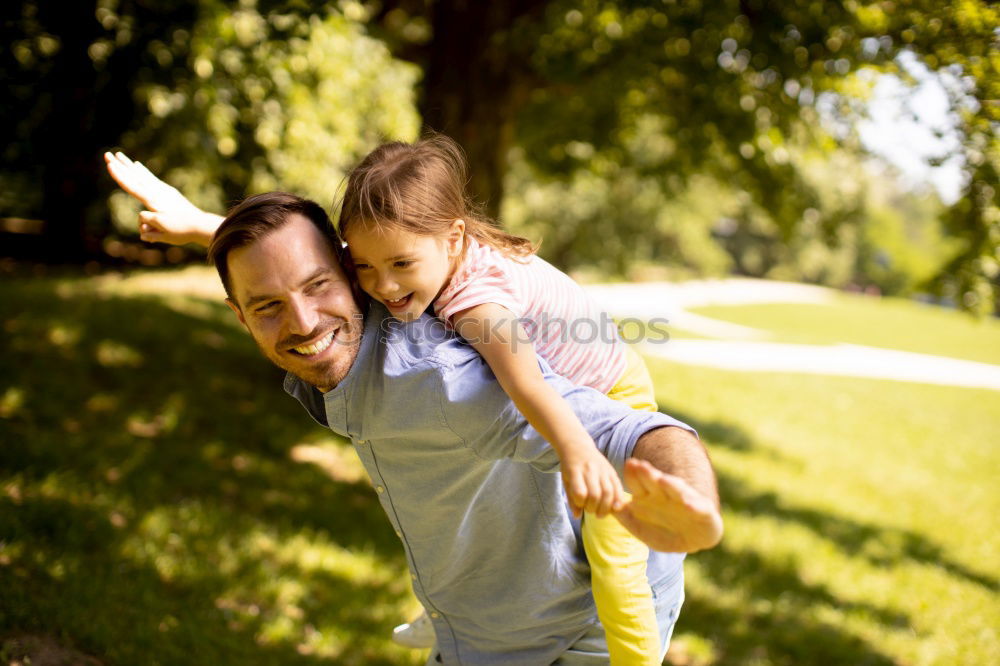 Similar – Back view of senior man holding adorable baby girl in his arms over a nature background