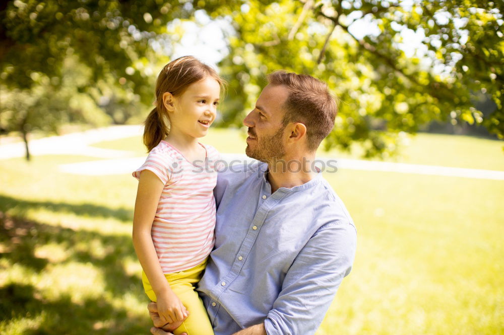 Similar – Back view of senior man holding adorable baby girl in his arms over a nature background