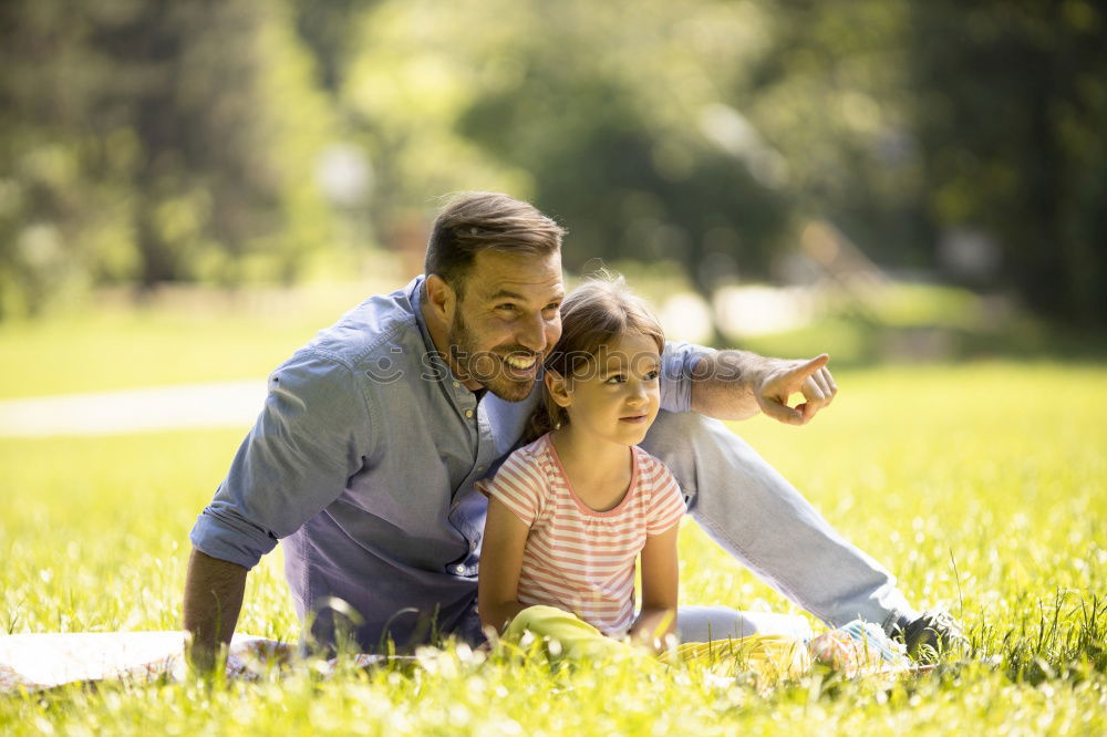 Similar – Back view of senior man holding adorable baby girl in his arms over a nature background