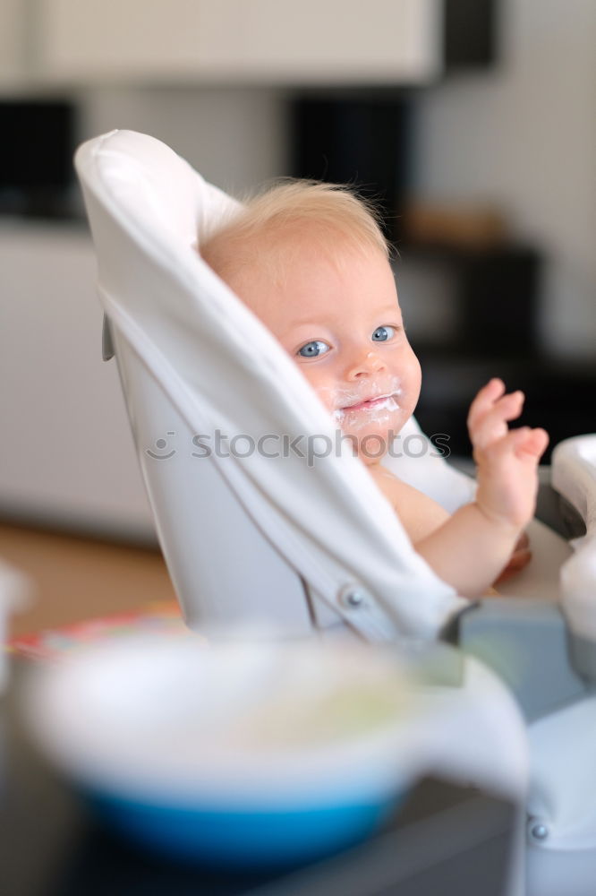 Similar – Baby toddler sits interested and curious in front of washing machine on the floor