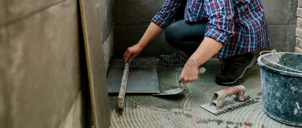 Female mason laying tiles on a terrace