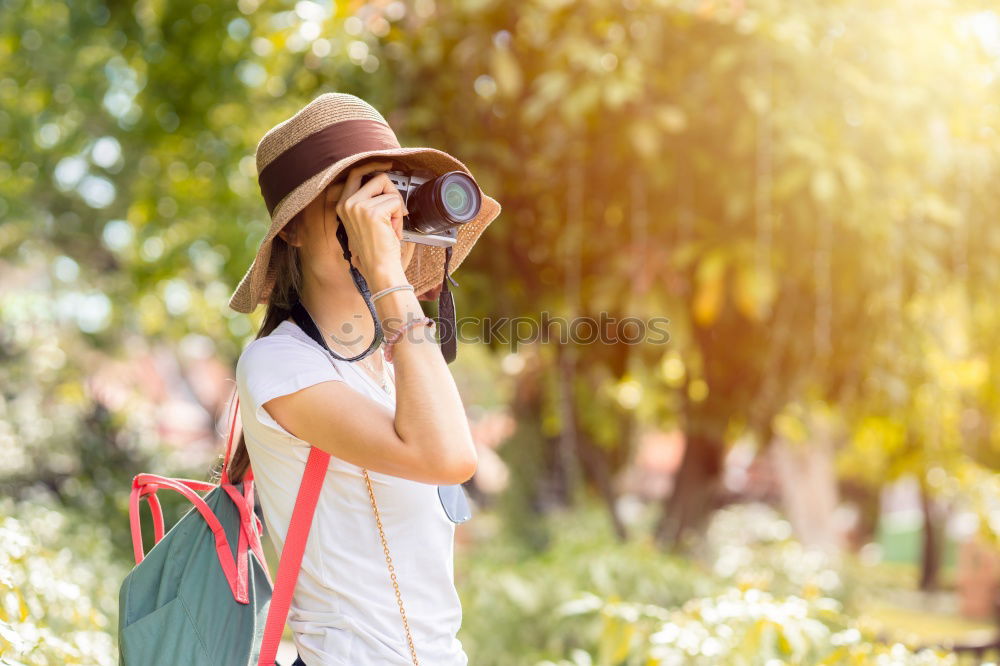 Similar – Smiling young woman using a camera to take photo at the park.