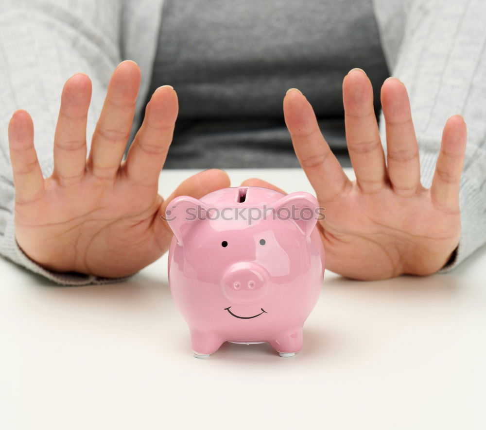 Similar – Unhappy man angry at his piggy bank