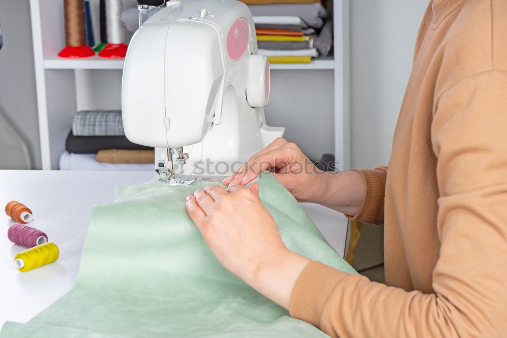 Similar – Women sew on sewing machine