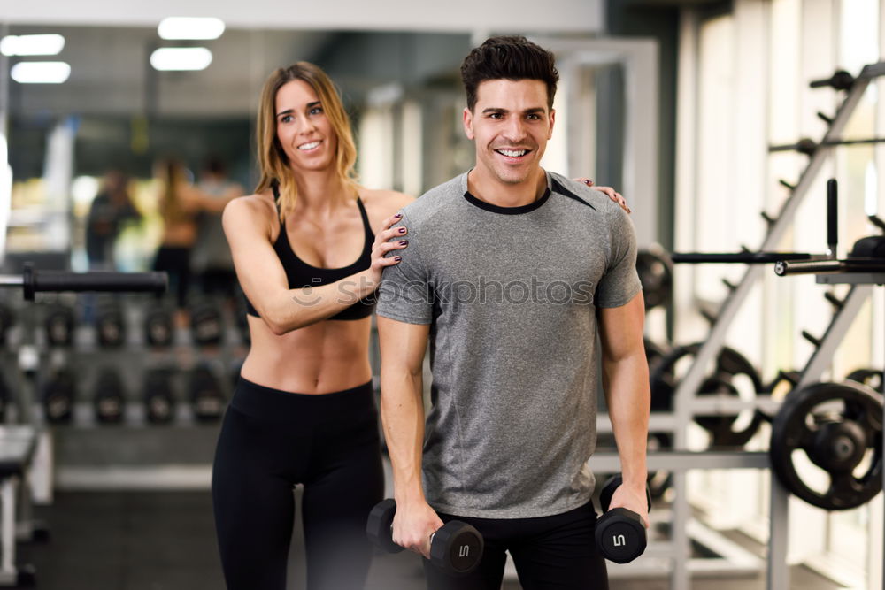 Man and woman personal trainers in the gym.