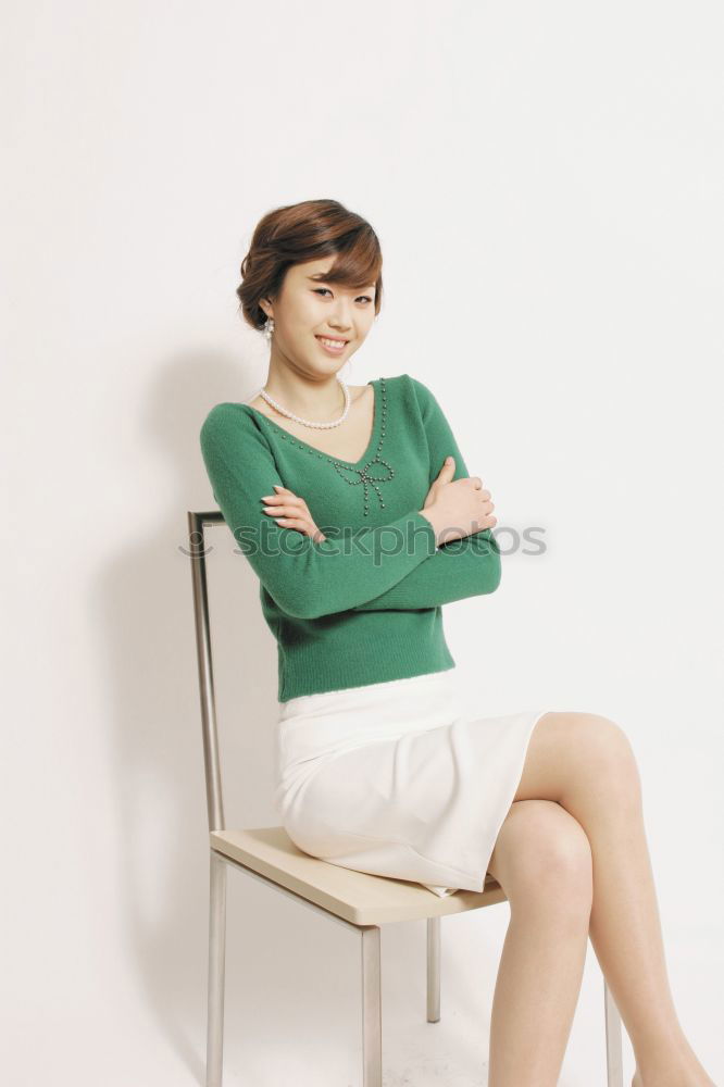 Similar – Elegant businesswoman looking at camera while sitting on stairs against of white wall