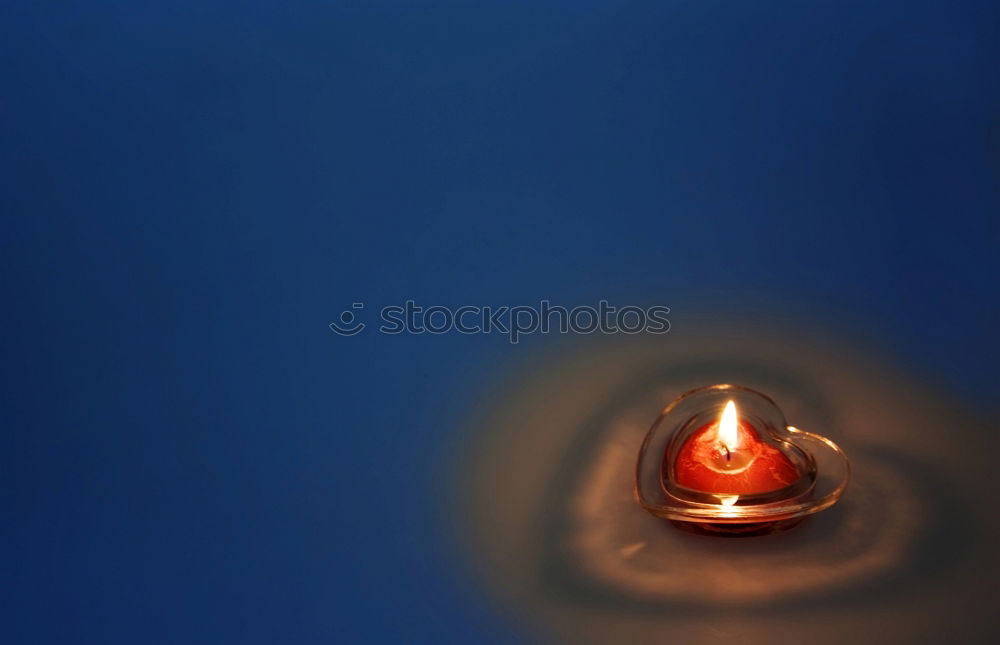 Image, Stock Photo two red burning candles stand one behind the other in front of a turquoise background