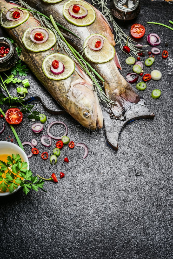 Similar – Raw fish on white paper with ingredients for cooking