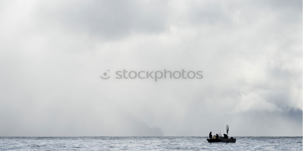 Similar – Fisher in the endless sea of water and clouds