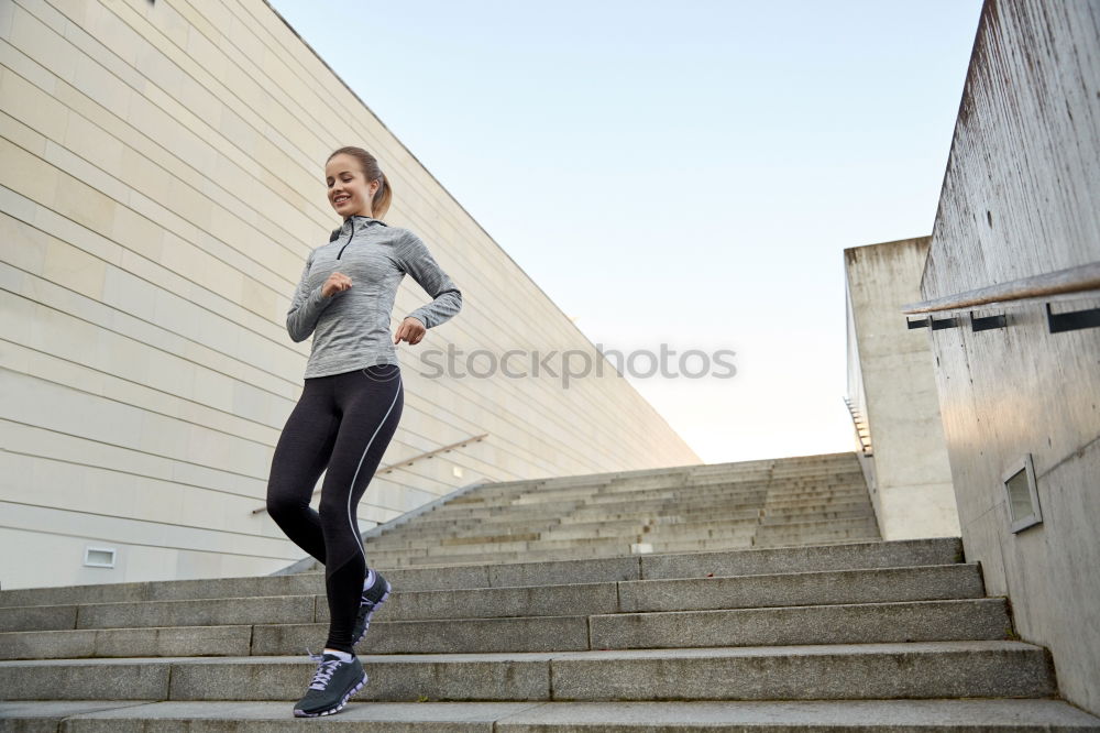 Woman stretching her body in front of ancient wall in park