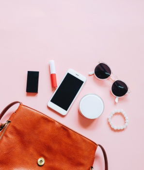 Flat lay of leather woman bag open out with cosmetics