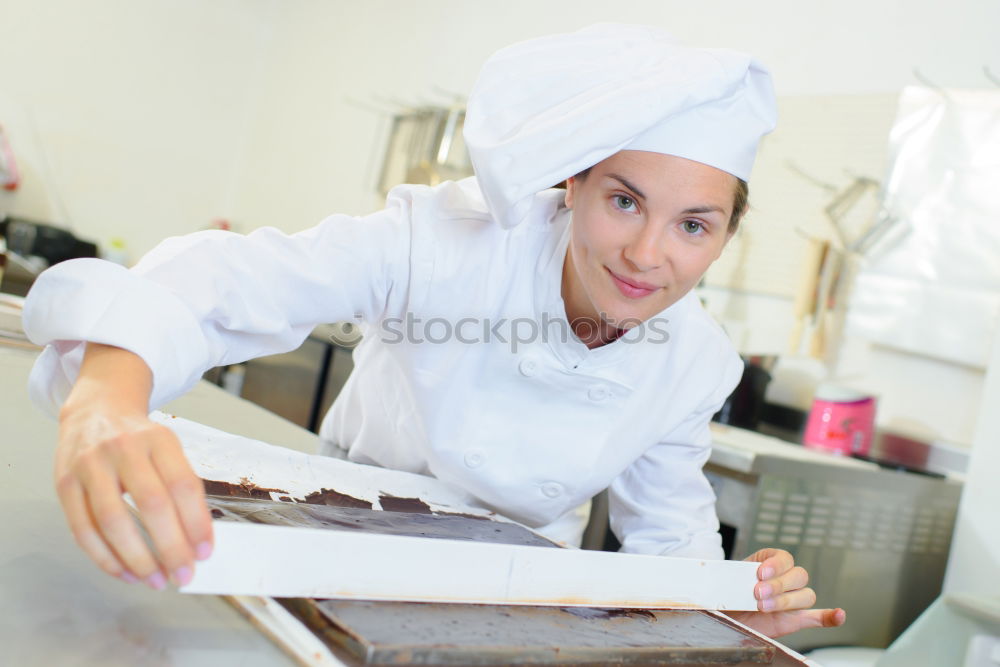 Similar – Image, Stock Photo A cook in a restaurant wearing a mask as a precaution against the coronavirus preparing the meal.