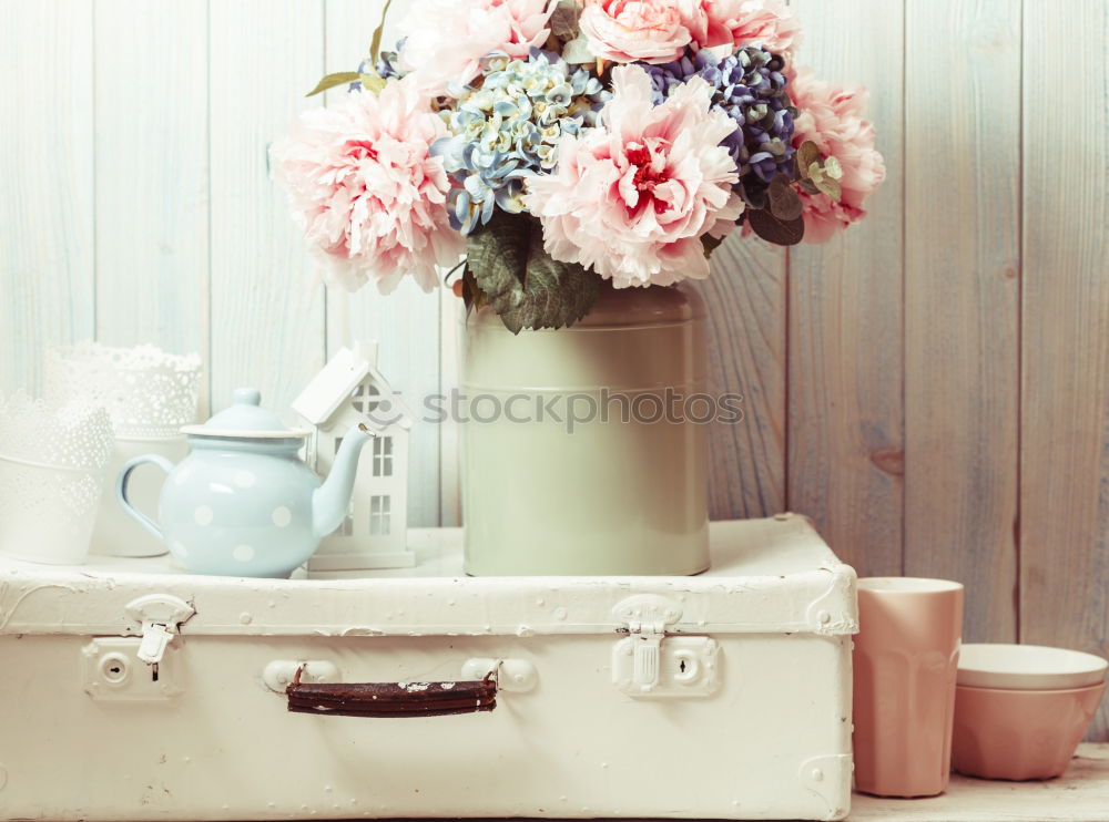 pink hydrangea flowers with watering can on wooden table