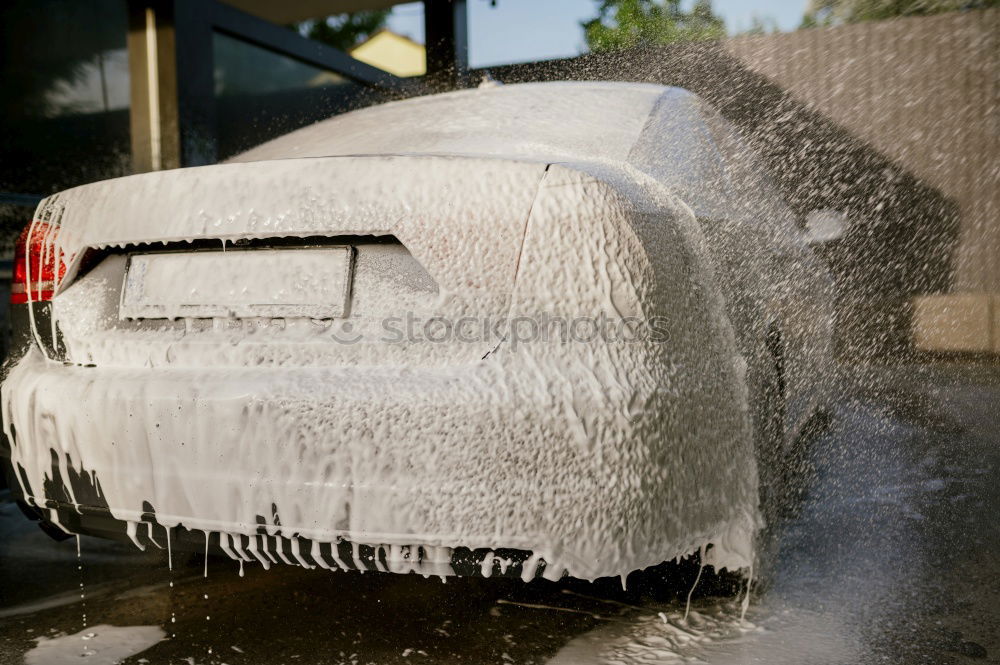 Similar – Whoosh!!! There thunders the dark car full through a deep puddle. A huge shower of water drenches the pedestrian with a colorful umbrella and red rubber boots.