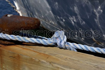 Ropes run through opening in the ship’s wall
